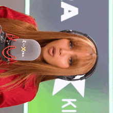 a woman wearing headphones and a microphone that says kiss extra