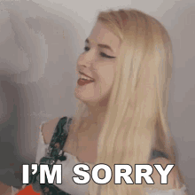 a blonde woman is saying i 'm sorry in front of a white background