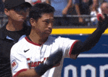 a baseball player wearing a white jersey with the word indians on the front