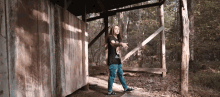 a person standing in front of a wooden structure with a black shirt that says ' apocalypse '