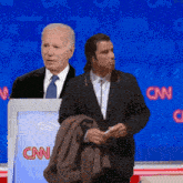 two men standing in front of a podium that says cnn on it