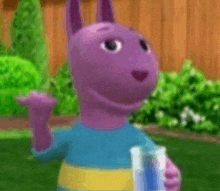 a purple cartoon character from backyardigans is standing in the grass holding a bottle .