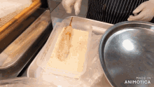 a person is preparing food in a plastic container that says made in animotica on the bottom