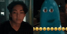 a man is standing next to a blue cartoon character with smiley faces on it .