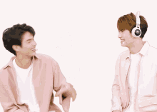 two men wearing pink shirts and headphones giving each other high fives