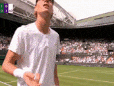 a man in a white shirt stands on a tennis court in front of a crowd and a scoreboard that says 1 0 1 ad