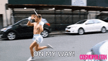 a man without a shirt is running down a street with the words on my way behind him