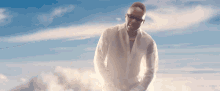 a man in a white shirt and white gloves is standing in the sky