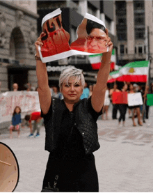 a woman holds up a piece of paper with a picture of a man on it and the word justice on it