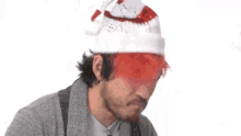 a man with red hair is wearing a santa hat .