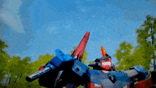 a red and blue robot with a sword on its back