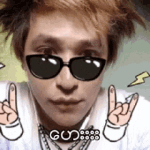 a close up of a person wearing sunglasses and a necklace that says gud8888