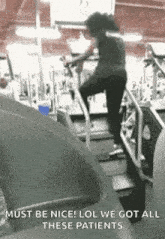 a woman is riding a treadmill in a gym while wearing a mask .