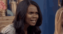 a woman is making a funny face while talking to another woman in a room .