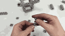 a person is holding a ball in their hand with a bunch of balls in the background