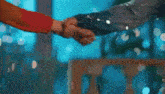 a close up of two people holding hands in a room .