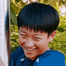 a young boy is smiling while holding a pole .