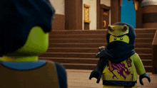 a lego figure with horns on his head stands next to another figure