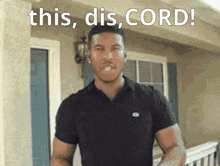 a man in a black shirt is standing in front of a house with the words this dis cord above him