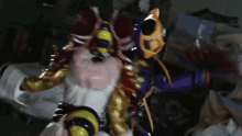 a man in a purple and gold costume is fighting another man in a white costume .