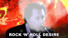 a man singing into a microphone with the words rock n ' roll desire above him