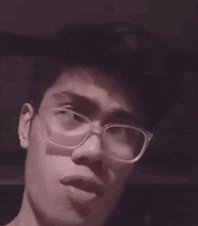 a man wearing glasses is eating a piece of food