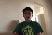 a boy wearing a green all good woods shirt