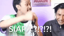 two men are standing next to each other in front of a sign that says siapa ? ! ? !
