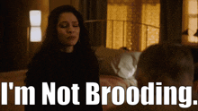 a woman sitting next to a man with the words i 'm not brooding