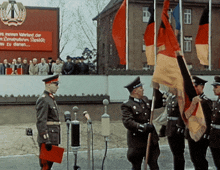 a man in a military uniform stands in front of a microphone holding a folder