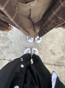 a person wearing a pair of crocs with a sticker on them