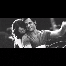 a black and white photo of a man and a woman hugging each other