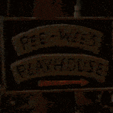 a sign for pee-wee 's playhouse has a red arrow pointing to the right