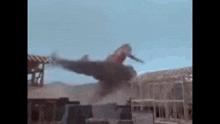 a fighter jet is flying through the air over a construction site .
