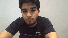a man with a beard wears a black jack & jones shirt