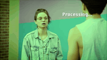 a woman in a denim jacket stands next to a man in a white tank top and the words processing are displayed on the screen