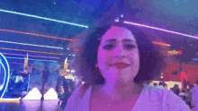 a woman in a white shirt is smiling in front of a sign that says ' shagarita '