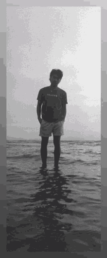 a black and white photo of a man standing in the water with a t-shirt that says safety