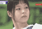 a close up of a woman 's face with a scoreboard behind her that says nimxxx
