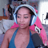 a woman wearing headphones holds a microphone in front of her face