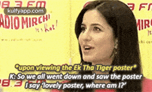 a woman is talking to someone while looking at a poster of a movie .