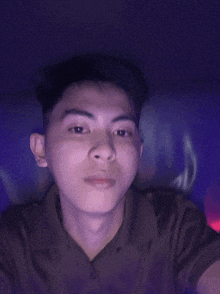 a young man is taking a selfie in front of a purple background