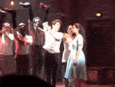 a group of people on a stage with a box on the wall