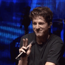 a young man is holding a microphone and smiling
