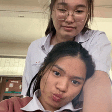 two girls are posing for a picture and one has a shirt that says ' a ' on it