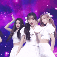 three girls in white dresses are dancing on stage