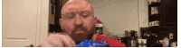 a bald man with a beard eating a bag of chips