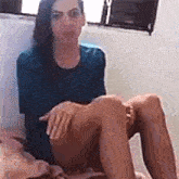 a woman is sitting on a bed with her legs crossed and a dog .