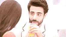 a man is drinking orange juice while looking at a woman
