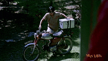 a man sits on a motorcycle with a box on the back and the license plate bal18537